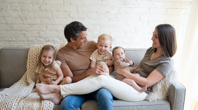 Family sitting on couch, smiling - Meghan Doll Photography